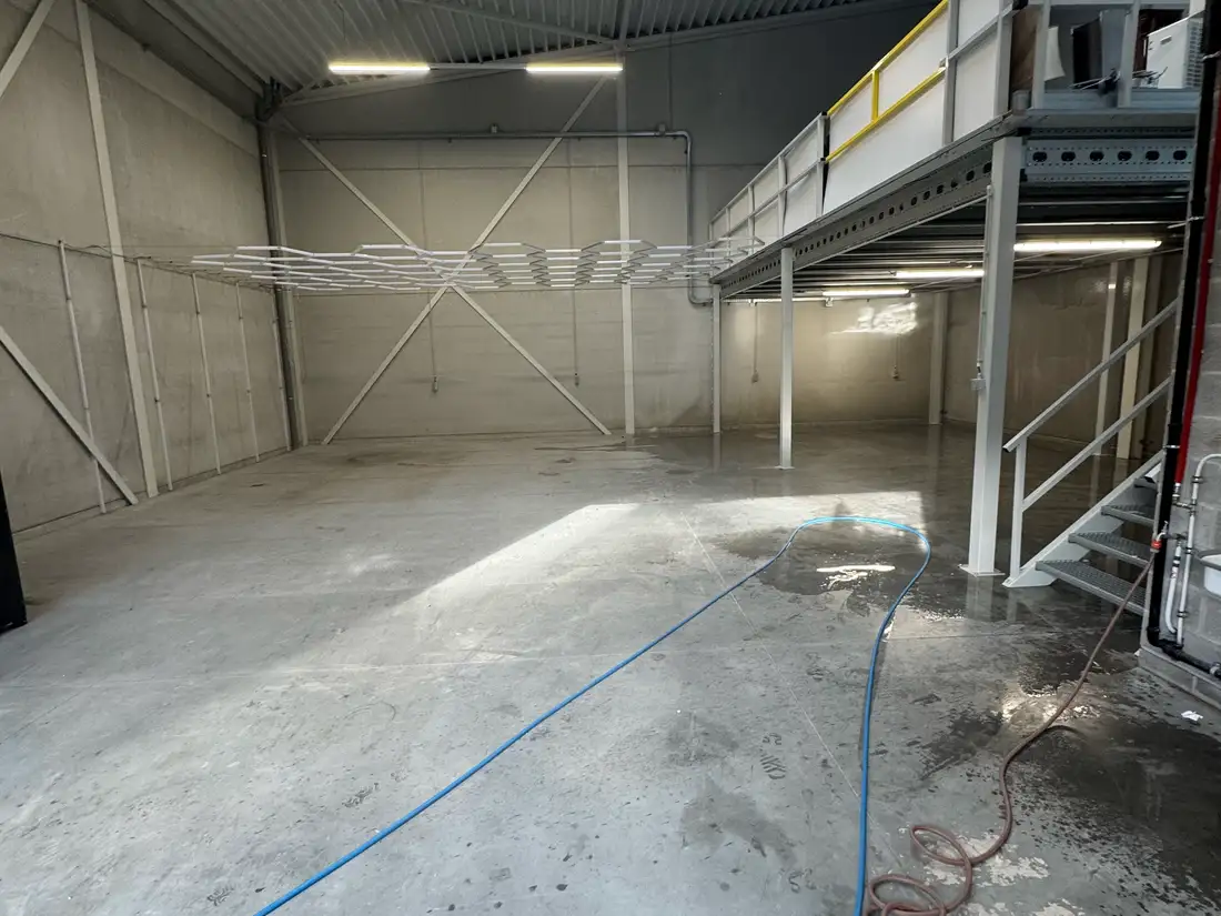 Vloerreiniging Lier — De vloer bij aankomst: dof, grauw en gevlekt beton.
